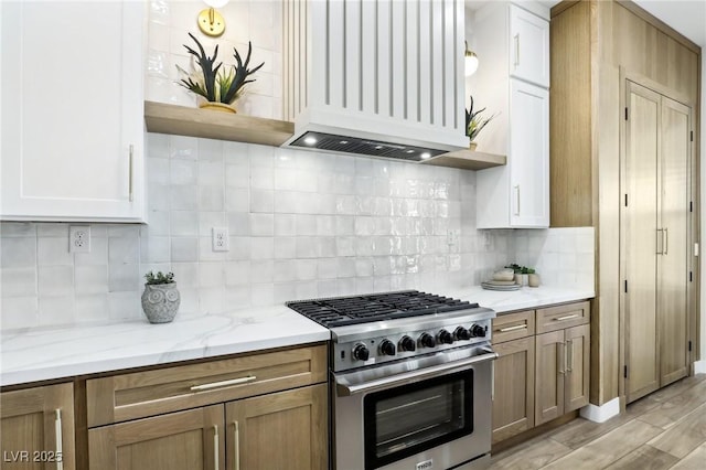 kitchen featuring open shelves, light stone countertops, premium range hood, tasteful backsplash, and high end stove
