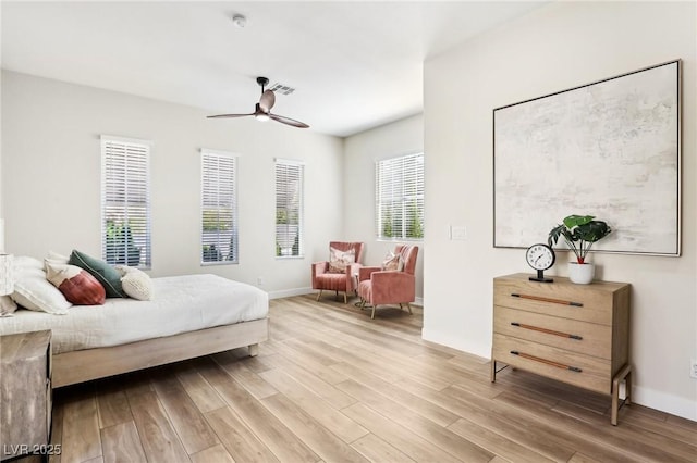 bedroom featuring visible vents, light wood finished floors, ceiling fan, and baseboards