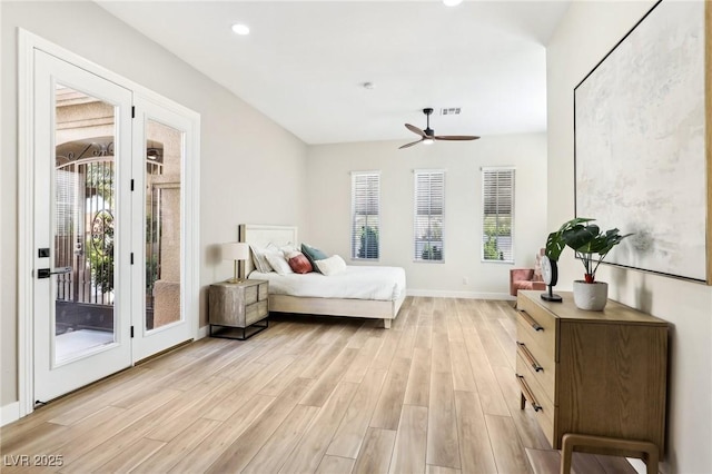 bedroom featuring baseboards, access to outside, multiple windows, and light wood-style flooring
