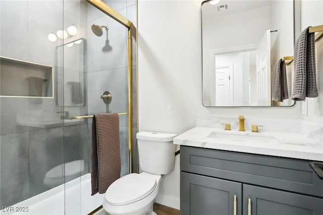 bathroom with toilet, visible vents, a shower with shower door, and vanity
