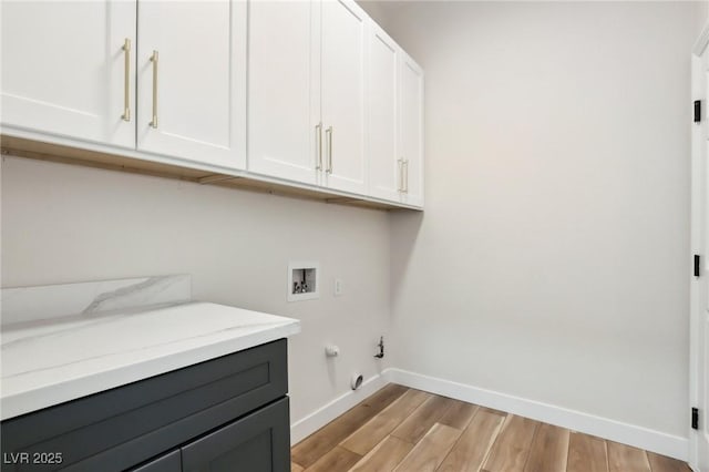 washroom with cabinet space, washer hookup, light wood-style flooring, baseboards, and hookup for a gas dryer