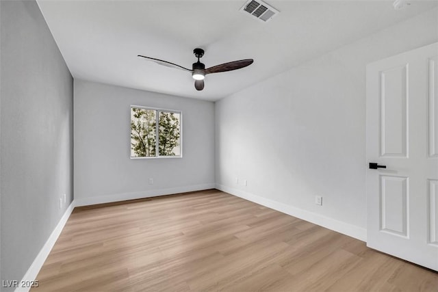 spare room with baseboards, ceiling fan, light wood finished floors, and visible vents