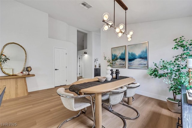 dining space featuring a chandelier, visible vents, and light wood-style floors