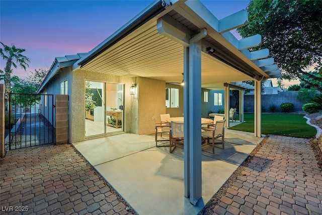 view of patio / terrace featuring fence, a gate, and outdoor dining space