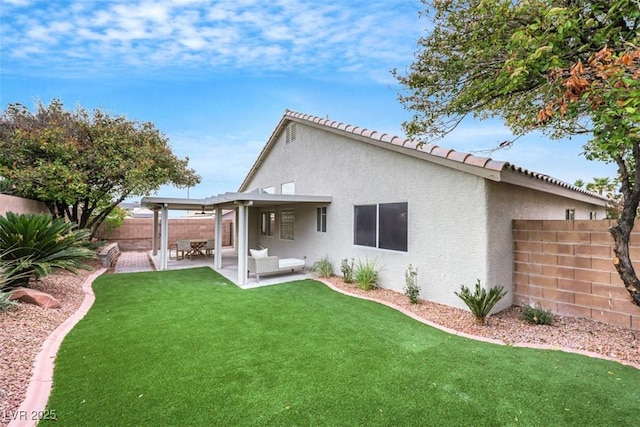 back of property with a fenced backyard, stucco siding, an outdoor hangout area, a patio area, and a lawn