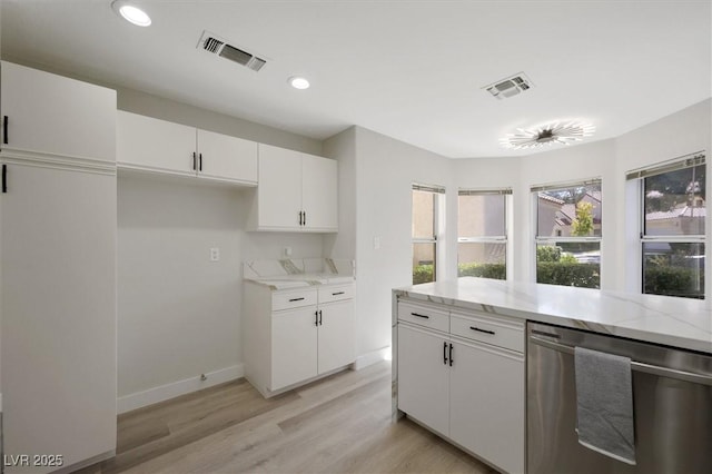 kitchen with light stone countertops, light wood-style floors, white cabinetry, stainless steel dishwasher, and visible vents