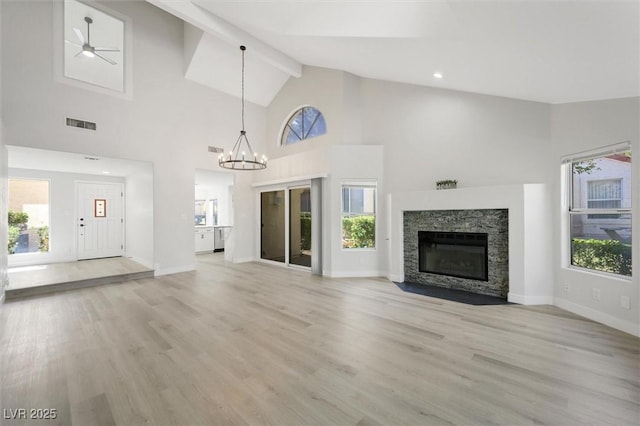 unfurnished living room featuring high vaulted ceiling, a wealth of natural light, and light wood-style floors
