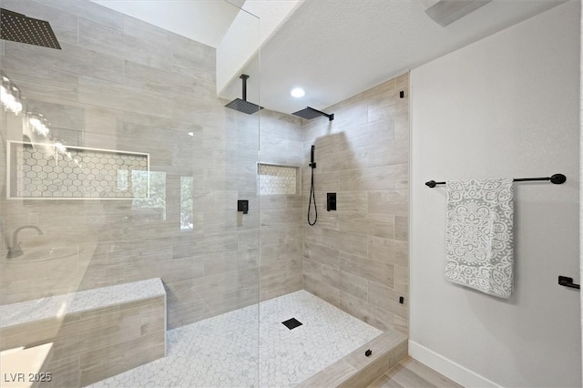 bathroom featuring baseboards and a tile shower