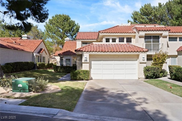 mediterranean / spanish-style house with a tiled roof, driveway, a front lawn, an attached garage, and stucco siding