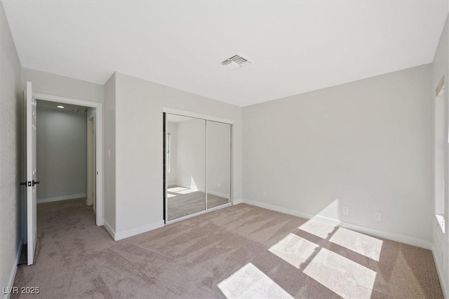 unfurnished bedroom featuring a closet, carpet flooring, and visible vents