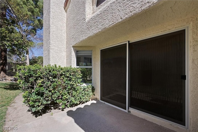 entrance to property featuring stucco siding