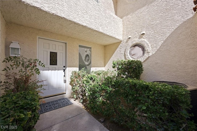 doorway to property featuring stucco siding