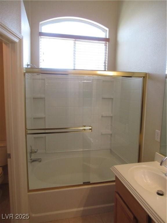 bathroom featuring vanity, toilet, and shower / bath combination with glass door