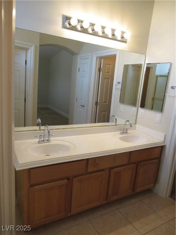 bathroom featuring tile patterned flooring, a sink, and double vanity