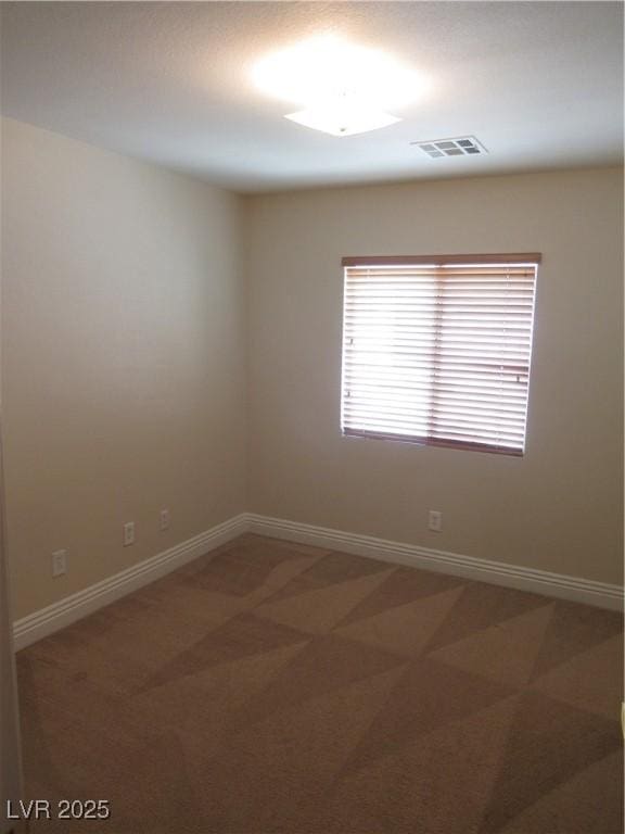 empty room featuring visible vents, baseboards, and light colored carpet