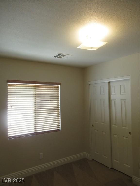 spare room with baseboards and visible vents