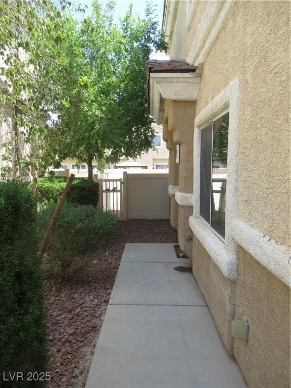 view of property exterior featuring stucco siding and fence