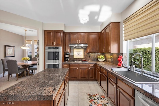 2933 Red Springs Dr, Las Vegas, NV 89135 - kitchen with stainless steel appliances, backsplash, under cabinet range hood, and light tile patterned floors