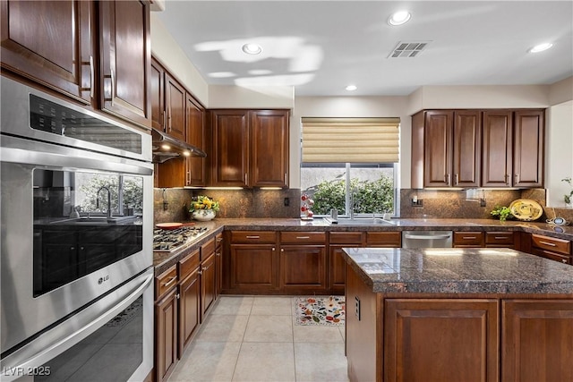 2933 Red Springs Dr, Las Vegas, NV 89135 - kitchen with stainless steel appliances, tile counters, decorative backsplash, light tile patterned floors, and recessed lighting