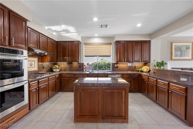 2933 Red Springs Dr, Las Vegas, NV 89135 - kitchen with appliances with stainless steel finishes, light tile patterned floors, a center island, under cabinet range hood, and recessed lighting