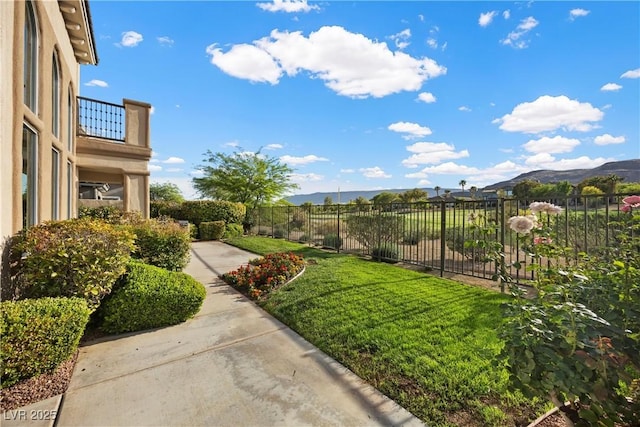 view of yard with a balcony and a mountain view