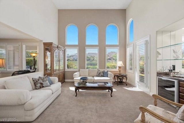 2933 Red Springs Dr, Las Vegas, NV 89135 - carpeted living area featuring beverage cooler, a high ceiling, and healthy amount of natural light