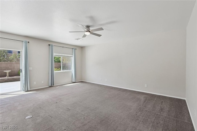 carpeted spare room featuring baseboards, a ceiling fan, and visible vents