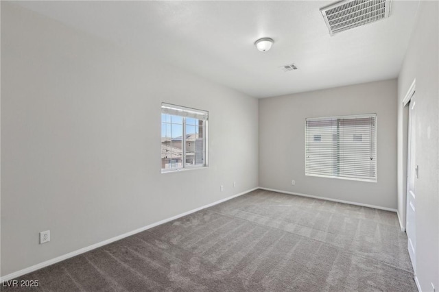 spare room featuring baseboards, carpet flooring, and visible vents