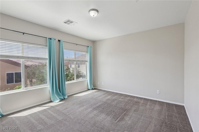 carpeted empty room featuring baseboards and visible vents