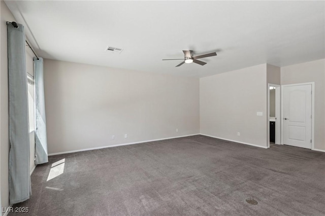 empty room with visible vents, a ceiling fan, baseboards, and dark carpet
