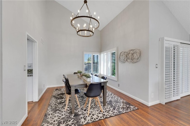 4680 Freshwater Dr, Las Vegas, NV 89103 - dining room featuring baseboards, wood finished floors, a notable chandelier, and high vaulted ceiling