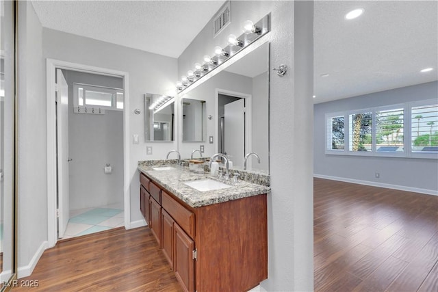 4680 Freshwater Dr, Las Vegas, NV 89103 - bathroom with baseboards, visible vents, a sink, and wood finished floors