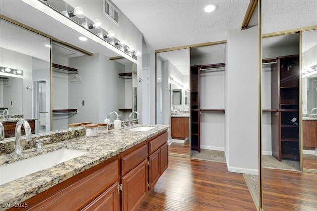 4680 Freshwater Dr, Las Vegas, NV 89103 - bathroom with visible vents, a sink, wood finished floors, and double vanity