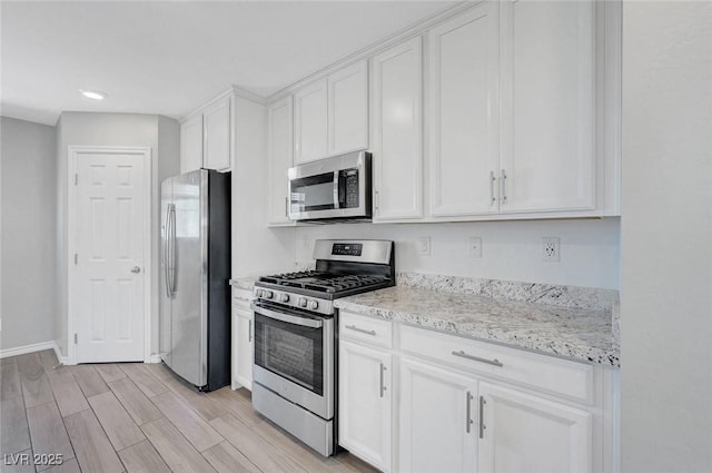 96 Campbelltown Ave, Henderson, NV 89015 - kitchen with baseboards, light wood-style flooring, white cabinetry, and appliances with stainless steel finishes