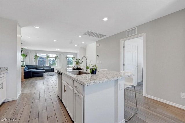 96 Campbelltown Ave, Henderson, NV 89015 - kitchen featuring a sink, a kitchen bar, light wood-type flooring, and visible vents