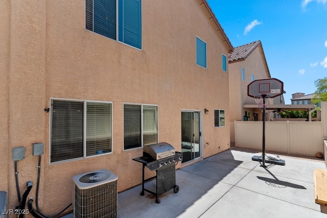 back of house featuring fence, stucco siding, cooling unit, and a patio area