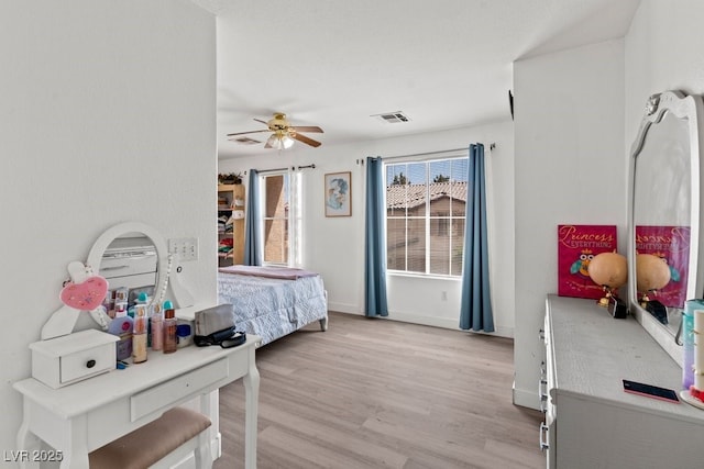 bedroom with visible vents, light wood finished floors, ceiling fan, and baseboards
