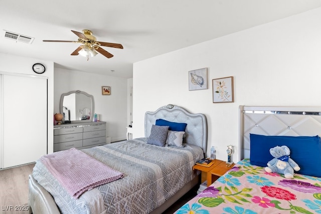 bedroom featuring visible vents, ceiling fan, and wood finished floors