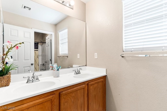 bathroom with visible vents, a sink, curtained shower, and double vanity