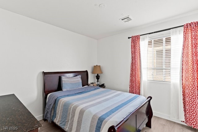 bedroom featuring baseboards, visible vents, and light wood-style floors