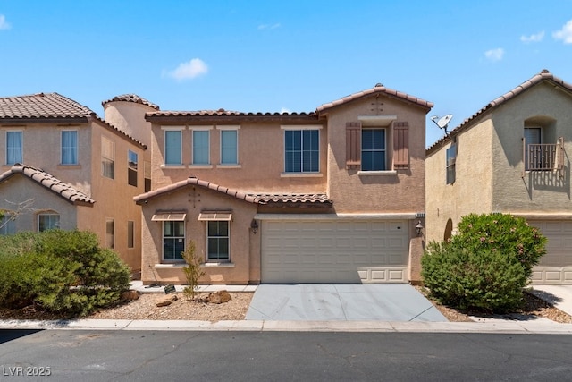 view of front of property with stucco siding, concrete driveway, a tile roof, and a garage