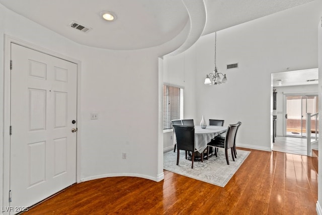 dining room featuring visible vents, wood finished floors, and a notable chandelier