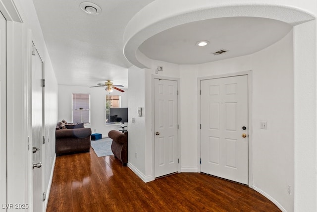 foyer featuring baseboards, ceiling fan, visible vents, and wood finished floors