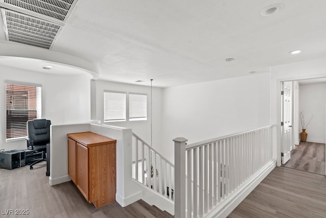 hall featuring plenty of natural light, visible vents, wood finished floors, and an upstairs landing