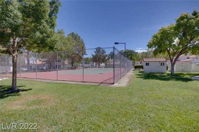 view of sport court featuring fence and a yard