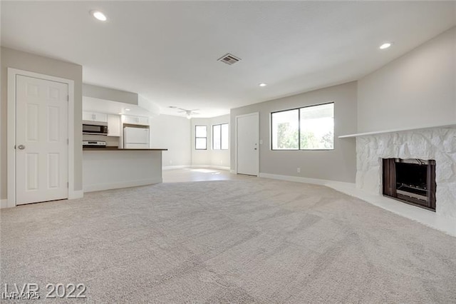 unfurnished living room featuring visible vents, a fireplace, baseboards, recessed lighting, and light colored carpet