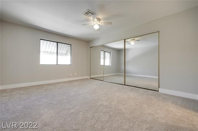 unfurnished bedroom with carpet floors, baseboards, a closet, and visible vents
