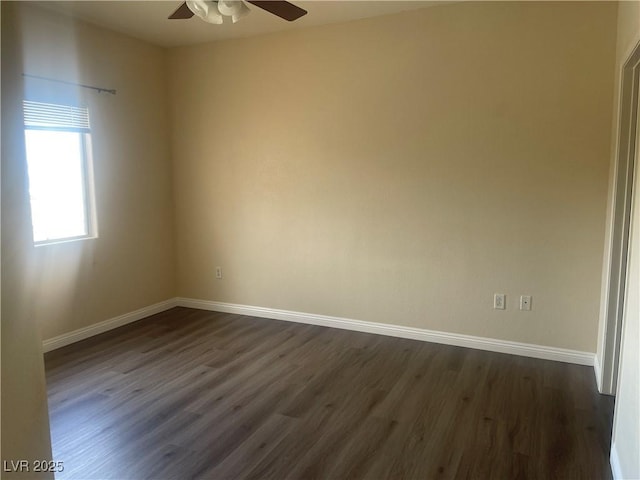 spare room featuring baseboards, a ceiling fan, and dark wood finished floors