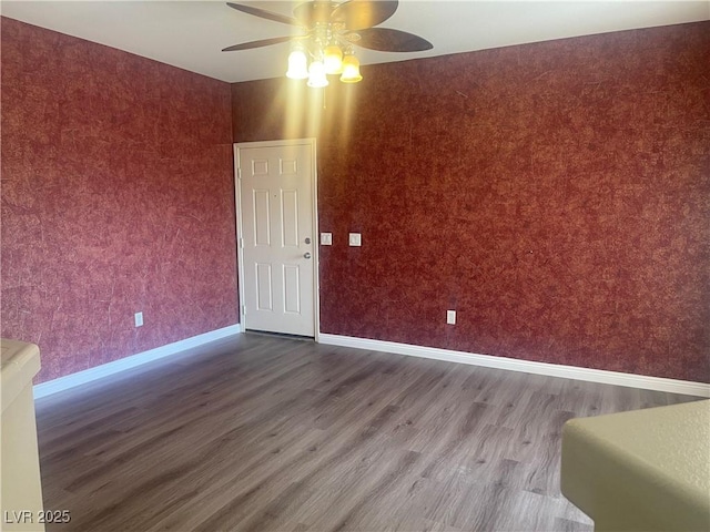 spare room featuring baseboards, a ceiling fan, and wood finished floors