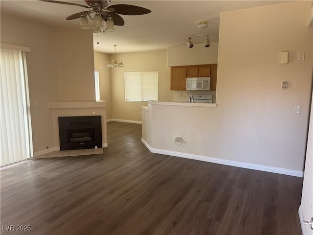 1050 E Cactus Ave Unit 2110, Las Vegas, NV 89183 - unfurnished living room with ceiling fan, dark wood-style floors, baseboards, and a fireplace with flush hearth
